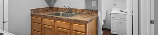an empty kitchen with wooden cabinets and a sink