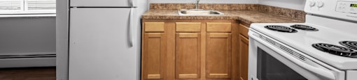 a kitchen with white appliances and wooden cabinets