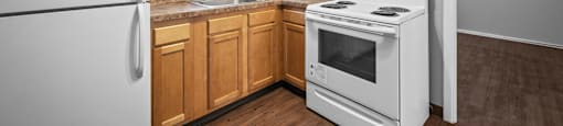 a kitchen with white appliances and wooden cabinets