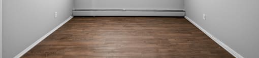 an empty room with wood floors and a window