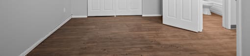 an empty room with white walls and a door to a bedroom