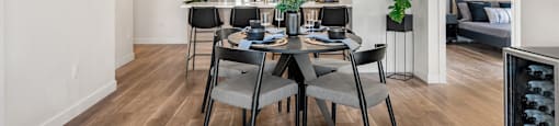 a dining room and kitchen area with a table and chairs