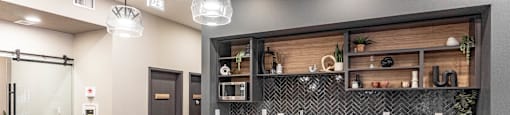 A modern kitchen with a white countertop and black chairs.