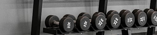 A person is lifting a kettlebell in a gym.