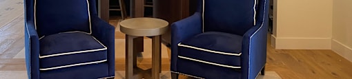 a lobby with two blue chairs and a table