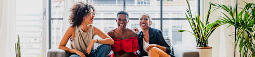 three people sitting on a couch in a living room