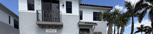 A two-story house with a balcony and a garage.