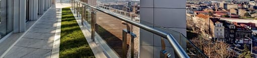 a balcony with grass and a view of the city