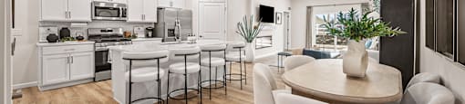 A modern kitchen with white cabinets and a dining table with chairs.