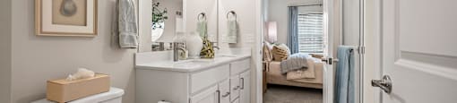 A white bathroom with a toilet, sink, and mirror.