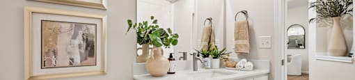 A white bathroom with a toilet, sink, and mirror.