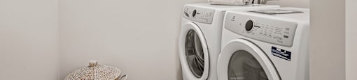 A white laundry room with a washer and dryer stacked on top of each other.
