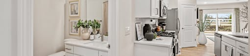 A white bathroom with a toilet, sink, and mirror.