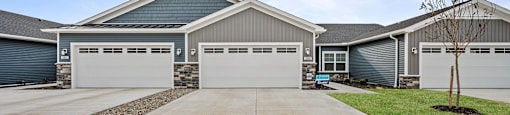 A large house with a grey roof and a white garage door.