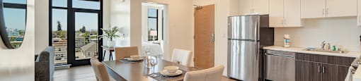 A modern kitchen with a dining table and chairs.
