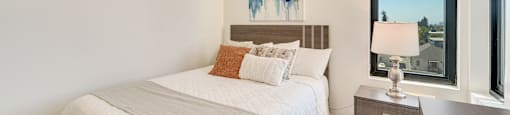 A bedroom with a large bed and a painting on the wall.