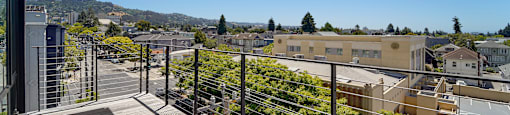 A balcony with a railing overlooks a town.