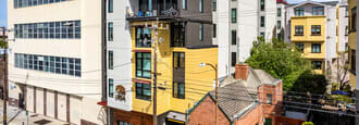 a yellow and white building sitting next to a white building