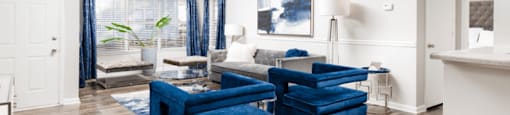 a living room with two blue chairs and a couch