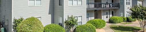 a white apartment building with cars parked in front of it