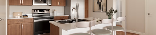 A modern kitchen with wooden cabinets and white countertops.at The Landing at Hub City, Plymouth, WI  