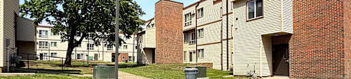 A grassy area in front of apartment buildings.