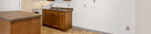 A kitchen with a refrigerator, stove, and cabinets.