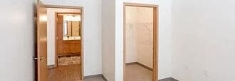 a second bedroom with carpeted floor and a window showing outside.