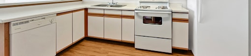A kitchen with white appliances and wooden cabinets.