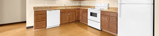 A kitchen with white appliances and wooden cabinets.