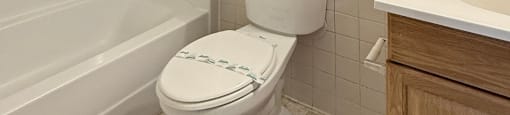 A white toilet with a white bathtub and a white sink in a bathroom.
