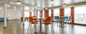 A room with tables and chairs is empty.