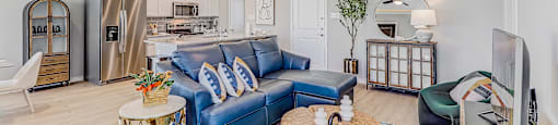 A living room with a blue couch and a wooden coffee table.