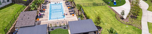 A swimming pool surrounded by houses and a fence.
