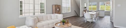 A living room with a white couch, a yellow chair, and a coffee table.