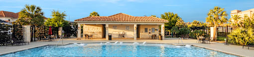 A large outdoor swimming pool with a fountain in the middle.
