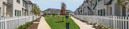 an empty sidewalk in front of a row of houses