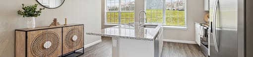 A kitchen with a white fridge and a round mirror on the wall.
