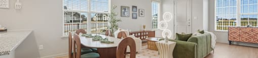 A dining room with a table set for six and a couch.