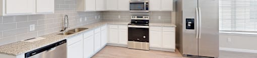 a kitchen with white cabinets and a stainless steel refrigerator