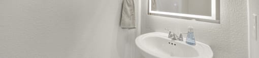 A bathroom with a white sink and a mirror.
