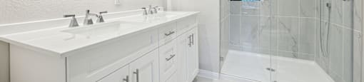Secondary bathroom with a walk-in shower and double sinks.
