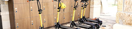 a row of scooters parked next to lockers in a locker room