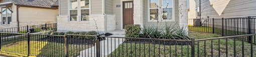 A house with a black fence in front of it.