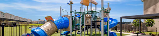 A playground with a blue slide and a yellow tower.