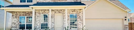 A house with a stone facade and a white garage door.