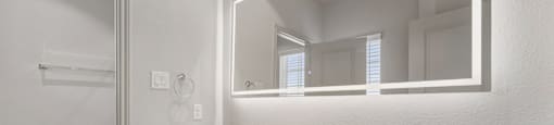 A white bathroom with a sink and mirror.