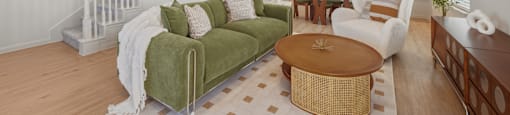 A living room with a green couch and a wooden coffee table.