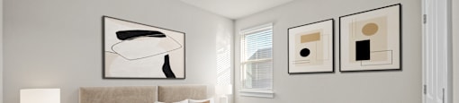 A bedroom with a large bed and two framed artworks on the wall.