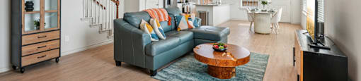 A living room with a blue couch and a wooden coffee table.